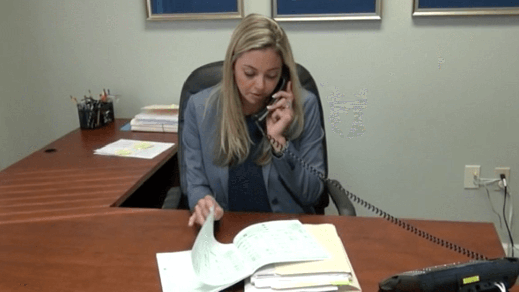 Dr. Panora takes a phone call and shuffles through paperwork on her desk.